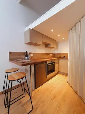 a kitchen with a counter and two stools in it at Studio entièrement rénové vieille ville in Ajaccio