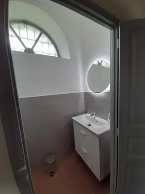 a white bathroom with a sink and a mirror at F3 FENETRE SUR JARDIN VUE MER ET MONTAGNE pour 4 VOYAGEURS in Ajaccio