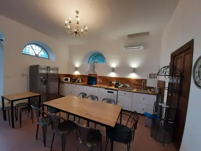 a kitchen with a table and chairs and a refrigerator at F3 FENETRE SUR JARDIN VUE MER ET MONTAGNE pour 4 VOYAGEURS in Ajaccio
