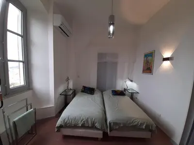 a bedroom with two beds and a window at F3 FENETRE SUR JARDIN VUE MER ET MONTAGNE pour 4 VOYAGEURS in Ajaccio