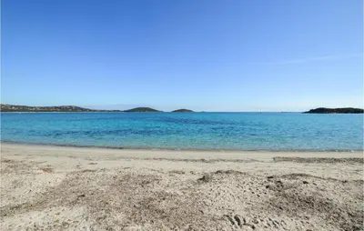a sandy beach with a large body of water at Cala Di Mare in Lecci