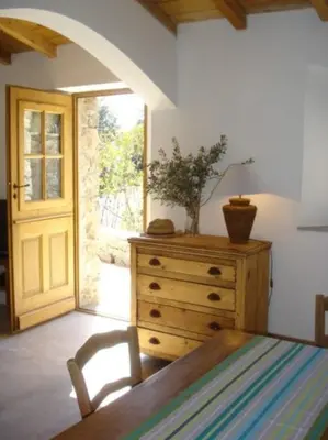 a bedroom with a bed and a dresser and a door at Les Bergeries de Piazzagina in Piediquarciu