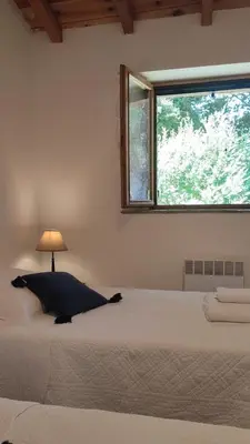 a bedroom with a large bed with a window at Les Bergeries de Piazzagina in Piediquarciu