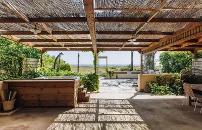 an outdoor patio with a wooden pergola at Oro Biancu in Lucciana