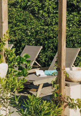 a lounge chair on a patio with a hedge at Oro Biancu in Lucciana