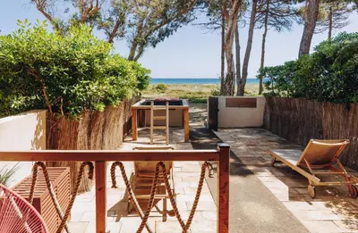a patio with a table and chairs and the ocean at Oro Biancu in Lucciana