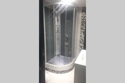 a shower with a glass door in a bathroom at Pavillon T2 proche ville dans petite résidence in Cuttoli-Corticchiato