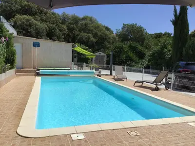 a large swimming pool with blue water at Pavillon T2 proche ville dans petite résidence in Cuttoli-Corticchiato