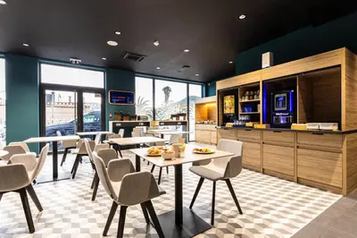 a dining room with tables and chairs in a restaurant at Holiday Inn Express Ajaccio by IHG in Ajaccio