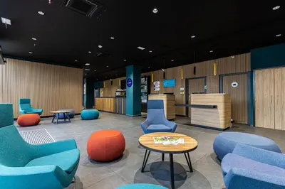 a waiting room with blue chairs and a table at Holiday Inn Express Ajaccio by IHG in Ajaccio