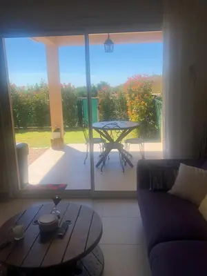a living room with a table and a large window at Mini-villa mitoyenne de type F2 proche Golfe de Lava in Appietto