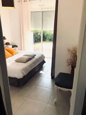 a bedroom with a bed and a window and a chair at Mini-villa mitoyenne de type F2 proche Golfe de Lava in Appietto