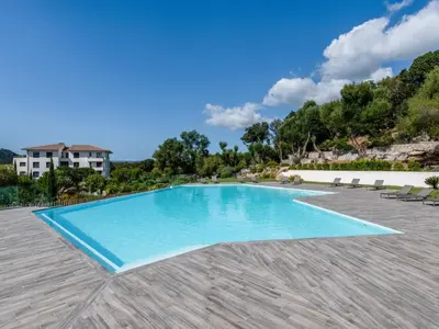 a swimming pool in a resort with blue water at Apartment Domaine d'Arca-2 by Interhome in Porto-Vecchio