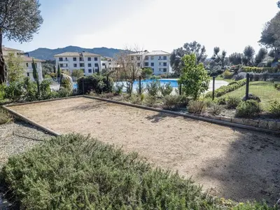 an empty yard with plants and buildings in the background at Apartment Domaine d'Arca-2 by Interhome in Porto-Vecchio
