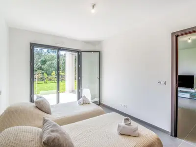 two beds in a room with a large window at Apartment Domaine d'Arca-2 by Interhome in Porto-Vecchio