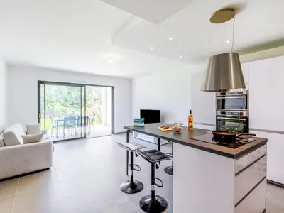 a kitchen with a island in a room with a couch at Apartment Domaine d'Arca-2 by Interhome in Porto-Vecchio