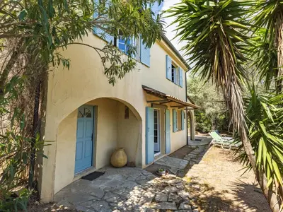 a house with a blue door and palm trees at Villa Villa Pavellone by Interhome in Porto-Vecchio