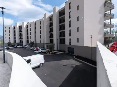 a parking lot with a white car parked in front of a building at Apartment Stanatura-1 by Interhome in Porto-Vecchio