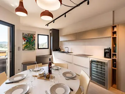 a kitchen with a table and chairs and a kitchen with white cabinets at Apartment Stanatura-1 by Interhome in Porto-Vecchio