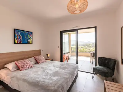 a bedroom with a bed and a chair and a window at Apartment Stanatura-1 by Interhome in Porto-Vecchio