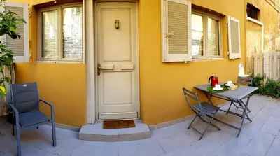 a table and chairs next to a house with a door at Studio centre ville in Ajaccio