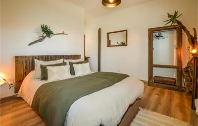 a bedroom with a large bed and a mirror at 2 Bedroom Cozy Home In Pila Canale in Pila-Canale