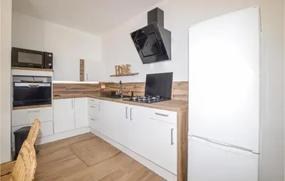 a kitchen with white cabinets and a stove at 2 Bedroom Cozy Home In Pila Canale in Pila-Canale