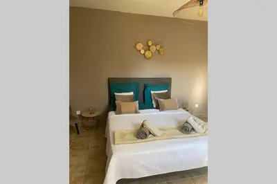 a bedroom with two white beds and a blue headboard at Suite spacieuse avec accès piscine in Ghisonaccia
