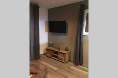 a living room with a flat screen tv on a wall at Suite spacieuse avec accès piscine in Ghisonaccia