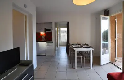a kitchen and dining room with a table and chairs at Résidence U Nebbiu in Olmeta-di-Tuda