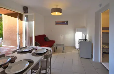 a kitchen and living room with a table and chairs at Résidence U Nebbiu in Olmeta-di-Tuda