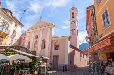 a church with a clock tower in a street at Magnifique Grand 30m2 refait à neuf en 2025 lumineux 4 couchages hyper centre Corte 13 cours paoli wifi tv lave linge in Corte