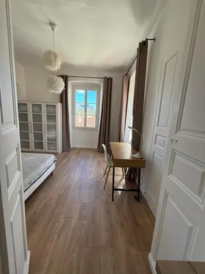 a bedroom with a bed and a desk and a window at Magnifique grand T3 refait à neuf en 2025 plein centre corte 13 cours paoli wifi écran plat lave linge 6 couchages in Corte