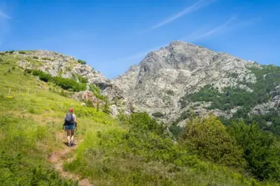 a person walking on a trail in the mountains at Magnifique grand T3 refait à neuf en 2025 plein centre corte 13 cours paoli wifi écran plat lave linge 6 couchages in Corte