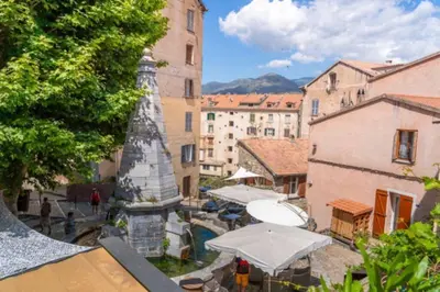 a view of a city with umbrellas and buildings at Magnifique grand T3 refait à neuf en 2025 plein centre corte 13 cours paoli wifi écran plat lave linge 6 couchages in Corte