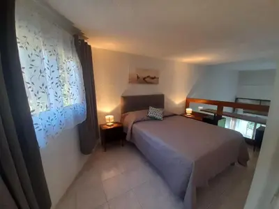 a bedroom with a bed and a window at PORTICCIO BRILOC APPART DUPLEX à 150m de la plage. in Porticcio