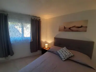 a bedroom with a bed with a pillow and a window at PORTICCIO BRILOC APPART DUPLEX à 150m de la plage. in Porticcio