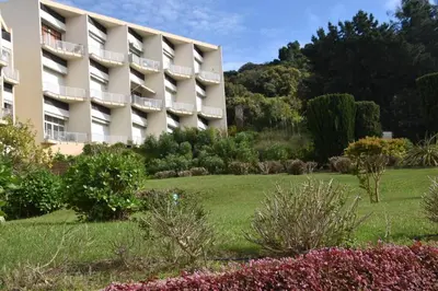 a hotel with a garden in front of a building at PORTICCIO BRILOC APPART DUPLEX à 150m de la plage. in Porticcio