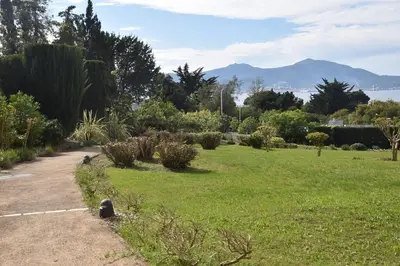 a park with a field of green grass and bushes at PORTICCIO BRILOC APPART DUPLEX à 150m de la plage. in Porticcio