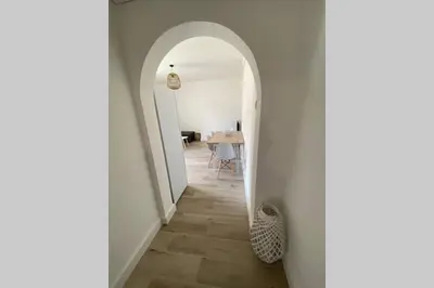 a hallway with an archway and a table in a room at Ajaccio magnifique T2 neuf 40m2 avec balcon au Trottel 4 couchages wifi Clim parking plage à pieds 100m in Ajaccio