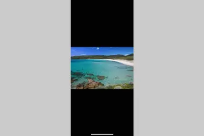 a television screen with a picture of a beach at Ajaccio magnifique T2 neuf 40m2 avec balcon au Trottel 4 couchages wifi Clim parking plage à pieds 100m in Ajaccio
