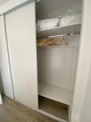 a closet with a glass door next to a bed at Ajaccio magnifique T2 neuf 40m2 avec balcon au Trottel 4 couchages wifi Clim parking plage à pieds 100m in Ajaccio