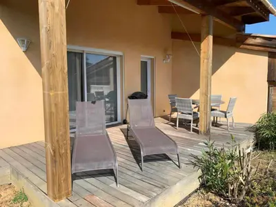 a wooden deck with chairs and a table on a house at Les Villas de Lava in Appietto