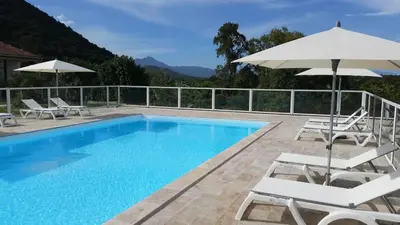 a swimming pool with chairs and umbrellas next to at LES TERRASSES D ACQUACITOSA in SERRA DI FIUMORBO