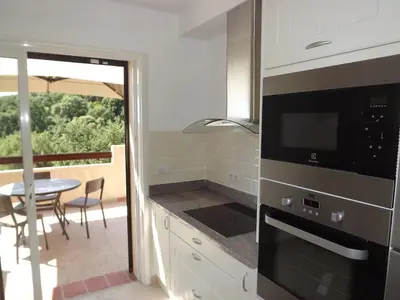 a kitchen with a stove top oven next to a table at LES TERRASSES D ACQUACITOSA in SERRA DI FIUMORBO