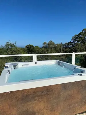 a hot tub on a balcony with a fence at LES TERRASSES D ACQUACITOSA in SERRA DI FIUMORBO
