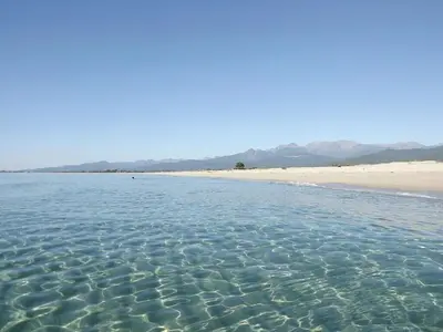 a body of water with a beach in the background at LES TERRASSES D ACQUACITOSA in SERRA DI FIUMORBO