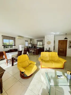 a living room with two yellow couches and a table at Superbe villa avec piscine vue mer, proche plage et Porticcio in Pietrosella