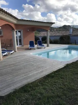a swimming pool with two chairs and a house at Superbe villa avec piscine vue mer, proche plage et Porticcio in Pietrosella