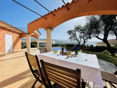 a table with a white table cloth on a patio at Superbe villa avec piscine vue mer, proche plage et Porticcio in Pietrosella